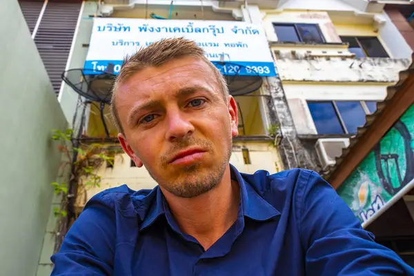 Yakışıklı erkek turist, Güneydoğu Asya 'da Khao Lak Amphoe Takua Pa Phang Nga Tayland' da bir otel girişinin önünde öfkeli bir şekilde bekliyor..