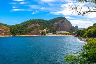 Rio de Janeiro Eyaleti Rio de Janeiro Brezilya 'da, Urca Red Beach Tropikal Cenneti Mavi Turkuaz Su Dalgaları Palmiye Ağaçları Kayalık Tepeler Kayalık Tepeler Sahil Kumu ve Beyaz Sahil Kumu.