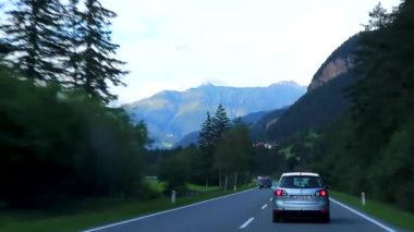 Alpler Tyrol Avusturya 12. Temmuz 2019 'da, yeşil tarlalar, arabalar ve Avusturya Alpleri' ndeki mavi gökyüzü ile otoyol üzerindeki bir dağ manzarası dağlarının içinden geçerken..