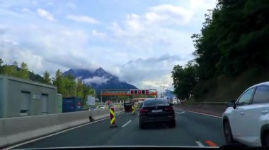 Alpler Tyrol Avusturya 12. Temmuz 2019 'da, yeşil tarlalar, arabalar ve Avusturya Alpleri' ndeki mavi gökyüzü ile otoyol üzerindeki bir dağ manzarası dağlarının içinden geçerken..
