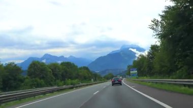 Alps Vorarlberg Avusturya 12. Temmuz 2019 'da, yeşil tarlalar, arabalar ve Alpler Vorarlberg Avusturya' da mavi gökyüzü olan otoyol üzerindeki bir dağ manzarası dağlarının içinden geçerken,.