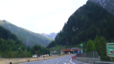 Alpler Tyrol Avusturya 12. Temmuz 2019 'da, yeşil tarlalar, arabalar ve Avusturya Alpleri' ndeki mavi gökyüzü ile otoyol üzerindeki bir dağ manzarası dağlarının içinden geçerken..