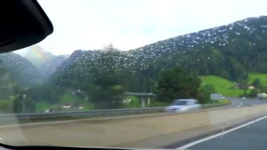 Alpler Tyrol Avusturya 12. Temmuz 2019 'da dağların arasından geçerek yağmur altında dağ yeşil tarlalar orman bulutları ve Alpler' deki bulutlu gökyüzü Tyrol Avusturya.