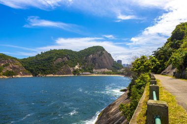 Rio de Janeiro Eyaleti Rio de Janeiro Brezilya 'da, Urca Red Beach Tropikal Cenneti Mavi Turkuaz Su Dalgaları Palmiye Ağaçları Kayalık Tepeler Kayalık Tepeler Sahil Kumu ve Beyaz Sahil Kumu.
