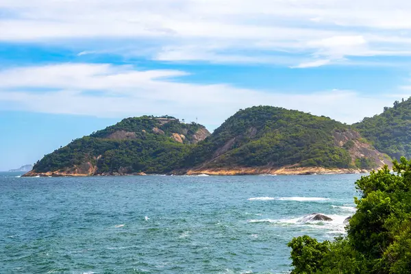 Rio de Janeiro Eyaleti Rio de Janeiro Brezilya 'da, Urca Red Beach Tropikal Cenneti Mavi Turkuaz Su Dalgaları Palmiye Ağaçları Kayalık Tepeler Kayalık Tepeler Sahil Kumu ve Beyaz Sahil Kumu.