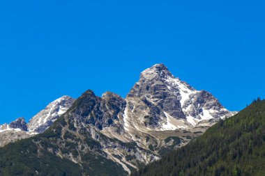 Dağ ve dağlık arazi dağları Alpler 'de kar, doğa ve mavi gökyüzü ile kayalar ve tepeler Tyrol Avusturya.