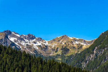 Dağ ve dağlık arazi dağları Alpler 'de kar, doğa ve mavi gökyüzü ile kayalar ve tepeler Tyrol Avusturya.