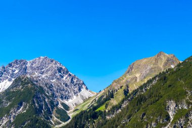 Dağ ve dağlık arazi dağları Alpler 'de kar, doğa ve mavi gökyüzü ile kayalar ve tepeler Tyrol Avusturya.