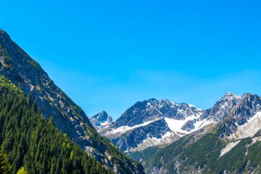 Dağ ve dağlık arazi dağları Alpler 'de kar, doğa ve mavi gökyüzü ile kayalar ve tepeler Tyrol Avusturya.