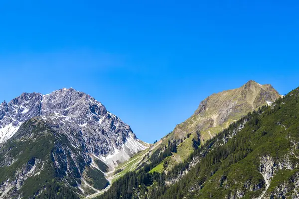 Dağ ve dağlık arazi dağları Alpler 'de kar, doğa ve mavi gökyüzü ile kayalar ve tepeler Tyrol Avusturya.