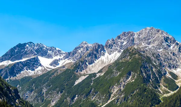 Dağ ve dağlık arazi dağları Alpler 'de kar, doğa ve mavi gökyüzü ile kayalar ve tepeler Tyrol Avusturya.