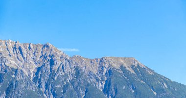 Dağ ve Alp tepeleri manzara dağları ve kayalar yeşil tarlalar ormanlar köknar ağaçları doğa ve mavi gökyüzü Alp Imst Tyrol Avusturya.