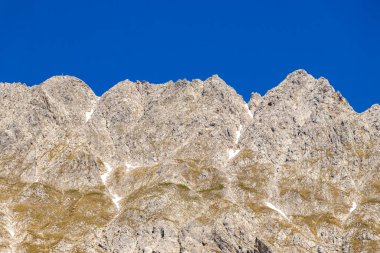 Dağ ve Alp Tepesi manzara dağları ve kayalar yeşil tarlaları olan manzaralar daha az orman ve köknar ağaçları Alpler Imst Tyrol Avusturya 'da kayalık doğa ve mavi gökyüzü.