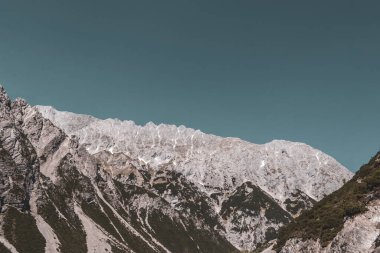 Dağ ve Alp Tepesi manzara dağları ve kayalar yeşil tarlaları olan manzaralar daha az orman ve köknar ağaçları Alpler Imst Tyrol Avusturya 'da kayalık doğa ve mavi gökyüzü.