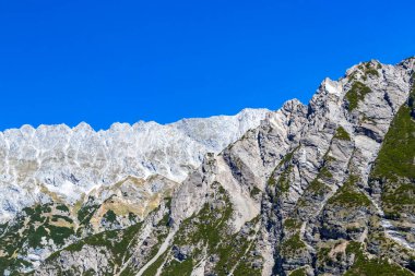 Dağ ve Alp Tepesi manzara dağları ve kayalar yeşil tarlaları olan manzaralar daha az orman ve köknar ağaçları Alpler Imst Tyrol Avusturya 'da kayalık doğa ve mavi gökyüzü.