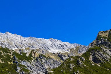 Dağ ve Alp Tepesi manzara dağları ve kayalar yeşil tarlaları olan manzaralar daha az orman ve köknar ağaçları Alpler Imst Tyrol Avusturya 'da kayalık doğa ve mavi gökyüzü.