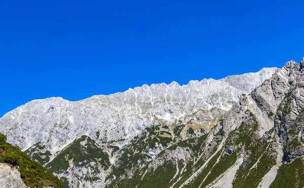 Dağ ve Alp Tepesi manzara dağları ve kayalar yeşil tarlaları olan manzaralar daha az orman ve köknar ağaçları Alpler Imst Tyrol Avusturya 'da kayalık doğa ve mavi gökyüzü.