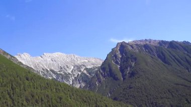 Yeşil tarlalı karayolu üzerindeki bir dağ manzarası dağlarının içinden geçen köknar ağaçları tepeler ve Alpler 'deki mavi gökyüzü Tyrol Avusturya.