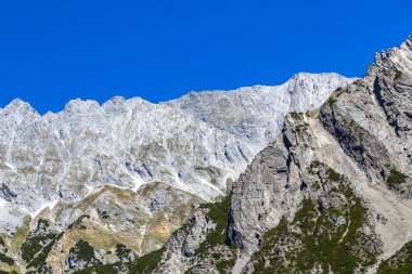Dağ ve Alp Tepesi manzara dağları ve kayalar yeşil tarlaları olan manzaralar daha az orman ve köknar ağaçları Alpler Imst Tyrol Avusturya 'da kayalık doğa ve mavi gökyüzü.