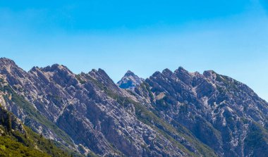 Dağ ve Alp Tepesi manzara dağları ve kayalar yeşil tarlaları olan manzaralar daha az orman ve köknar ağaçları Alpler Imst Tyrol Avusturya 'da kayalık doğa ve mavi gökyüzü.