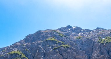 Dağ ve Alp Tepesi manzara dağları ve kayalar yeşil tarlaları olan manzaralar daha az orman ve köknar ağaçları Alpler Imst Tyrol Avusturya 'da kayalık doğa ve mavi gökyüzü.