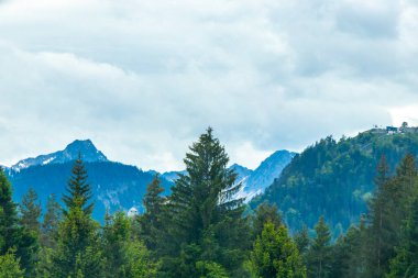 Dağ ve dağlık arazi dağları karla kaplı kaya ve tepeler ve manzaralar ve Alpler 'deki bulutlu mavi gökyüzü Reutte Tyrol Avusturya.
