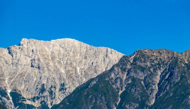 Dağ ve Alp tepeleri manzara dağları ve kayalar yeşil tarlalar ormanlar köknar ağaçları doğa ve mavi gökyüzü Alp Imst Tyrol Avusturya.
