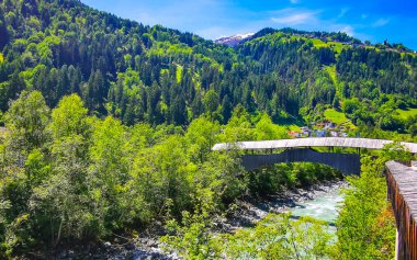 Turkuaz mavi ve yeşil nehir buharı ve köprü taşlı şelale hanı. Çimen ağaçları, doğa ve dağ manzarası. Alplerde uçan Landeck Tyrol Avusturya..