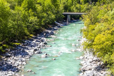 Turkuaz mavi ve yeşil nehir buharı ve köprü taşlı şelale hanı. Çimen ağaçları, doğa ve dağ manzarası. Alplerde uçan Landeck Tyrol Avusturya..
