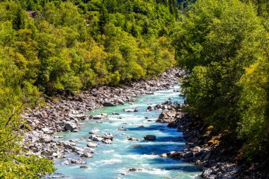 Turkuaz mavi ve yeşil nehir buharı ve köprü taşlı şelale hanı. Çimen ağaçları, doğa ve dağ manzarası. Alplerde uçan Landeck Tyrol Avusturya..