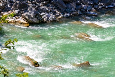 Turkuaz mavi ve yeşil nehir buharı ve köprü taşlı şelale hanı. Çimen ağaçları, doğa ve dağ manzarası. Alplerde uçan Landeck Tyrol Avusturya..