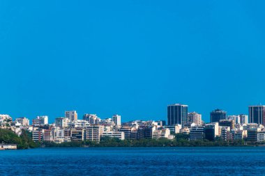 Rio de Janeiro Eyaleti Rio de Janeiro Brezilya 'da Barra da Tijuca Plajı Tropikal Cenneti Mavi Tepeler Su Palmiyeleri ve Şehir Skyline ile.