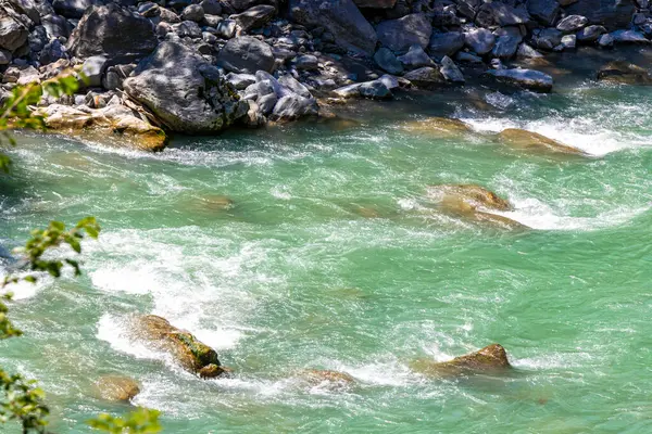 Turkuaz mavi ve yeşil nehir buharı ve köprü taşlı şelale hanı. Çimen ağaçları, doğa ve dağ manzarası. Alplerde uçan Landeck Tyrol Avusturya..