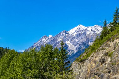 Dağ ve Alp tepeleri dağları, kayalar ve tepeler, Lechtal Alpleri, yeşil çayır köyü ormanı, kar ve mavi gökyüzü, Fliess Landeck Tyrol Avusturya 'da..