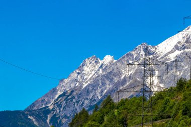 Dağlardaki elektrik direği dağ ve dağ manzarası dağlarında kayalar ve tepeler karlı Lechtal Alpleri 'nin manzarası ve Alpler' deki mavi gökyüzü Fliess Landeck Tyrol Avusturya.