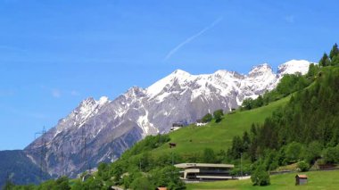 Dağ ve Alp tepeleri dağları, kayalar ve tepeler, Lechtal Alpleri, yeşil çayır köyü ormanı, kar ve mavi gökyüzü, Fliess Landeck Tyrol Avusturya 'da..