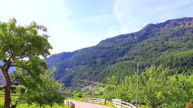 Dağ ve Alp Dağları 'ndaki patika caddeleri kayalar ve tepeler yeşil çayır çayırları Fliess Landeck Tyrol Avusturya' daki köy orman evleri.