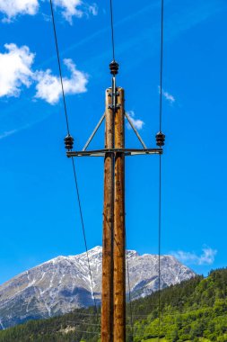 Dağlardaki elektrik direği dağ ve dağ manzarası dağlarında kayalar ve tepeler karlı Lechtal Alpleri 'nin manzarası ve Alpler' deki mavi gökyüzü Fliess Landeck Tyrol Avusturya.