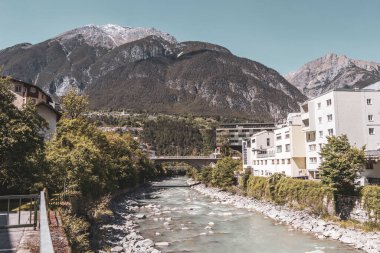 Landeck Tyrol Austria 30. May 2025 Turquoise blue and green river steam and Inn with bridge stones rocks trees nature and mountains in the Alps Landeck Tyrol Austria.