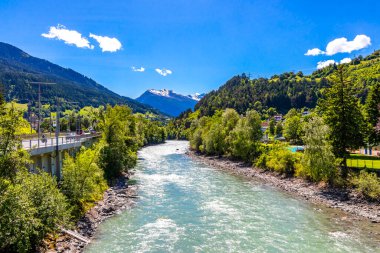 Turkuaz mavi ve yeşil nehir buharı ve taşlı şelale hanı. Alplerdeki dağların arasındaki çimen ağaçları. Landeck District Landeck Tyrol Austria..