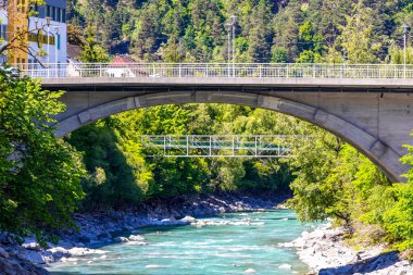 Landeck Tyrol Avusturya 30. Mayıs 2025 Turkuaz mavi ve yeşil nehir buharı ve köprü taşlı han Alpler Landeck Tyrol Avusturya 'daki doğa ve dağları sallıyor..