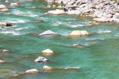 Turkuaz mavi ve yeşil nehir buharı ve taşlı şelale hanı. Alplerdeki dağların arasındaki çimen ağaçları. Landeck District Landeck Tyrol Austria..