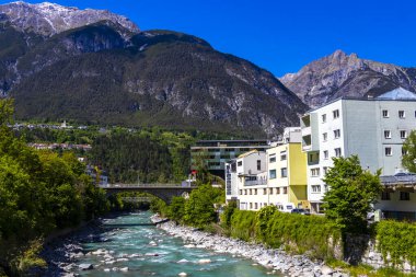 Landeck Tyrol Austria 30. May 2025 Turquoise blue and green river steam and Inn with bridge stones rocks trees nature and mountains in the Alps Landeck Tyrol Austria.