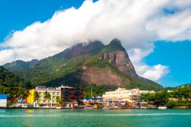 Rio de Janeiro Eyaleti Rio de Janeiro Brezilya 'da Barra da Tijuca Plajı Tropikal Cenneti Mavi Tepeler Su Palmiyeleri ve Şehir Skyline ile.