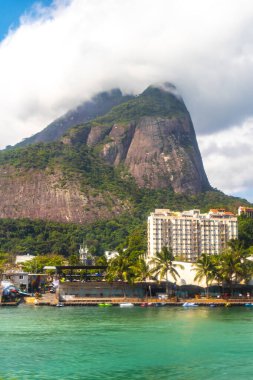 Rio de Janeiro Eyaleti Rio de Janeiro Brezilya 'da Barra da Tijuca Plajı Tropikal Cenneti Mavi Tepeler Su Palmiyeleri ve Şehir Skyline ile.