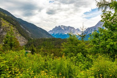 Almanya 'nın en büyük dağının panoramik manzarası Zugspitze alp manzarası turkuvaz rengi Blindsee gölü orman tepeleri ve Alpler' deki dağlar Biberwier Reutte Tyrol Avusturya.