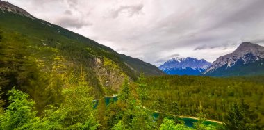 Almanya 'nın en büyük dağının panoramik manzarası Zugspitze alp manzarası turkuvaz rengi Blindsee gölü orman tepeleri ve Alpler' deki dağlar Biberwier Reutte Tyrol Avusturya.