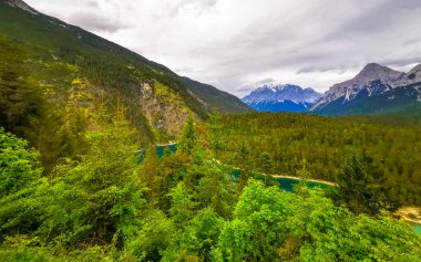 Almanya 'nın en büyük dağının panoramik manzarası Zugspitze alp manzarası turkuvaz rengi Blindsee gölü orman tepeleri ve Alpler' deki dağlar Biberwier Reutte Tyrol Avusturya.