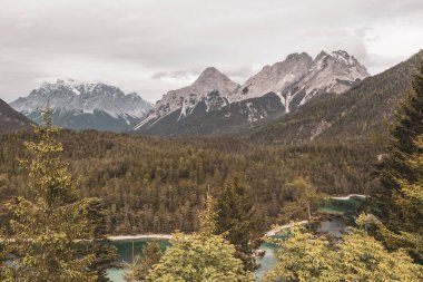 Almanya 'nın en büyük dağının panoramik manzarası Zugspitze alp manzarası turkuvaz rengi Blindsee gölü orman tepeleri ve Alpler' deki dağlar Biberwier Reutte Tyrol Avusturya.