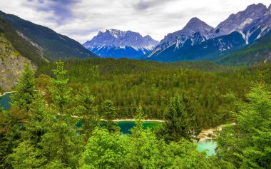 Almanya 'nın en büyük dağının panoramik manzarası Zugspitze alp manzarası turkuvaz rengi Blindsee gölü orman tepeleri ve Alpler' deki dağlar Biberwier Reutte Tyrol Avusturya.